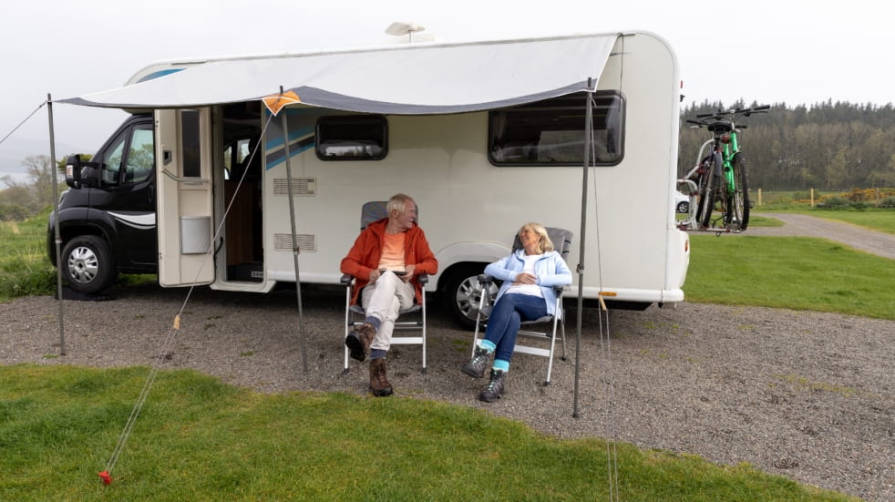 Couple sat outside motorhome 